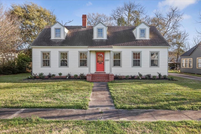 new england style home featuring a front lawn, a chimney, and a shingled roof