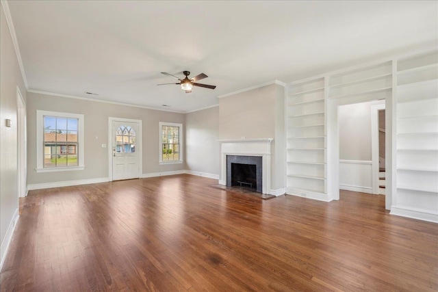 unfurnished living room featuring a healthy amount of sunlight, ceiling fan, a fireplace, and wood finished floors