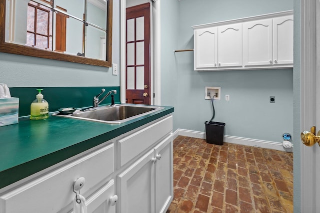 27076 Interstate 10, Winnie, TX 77665 - laundry area with hookup for an electric dryer, cabinet space, baseboards, brick flooring, and hookup for a washing machine