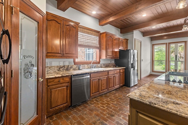 27076 Interstate 10, Winnie, TX 77665 - kitchen featuring stainless steel appliances, a sink, wooden ceiling with exposed beams, healthy amount of natural light, and brick floors