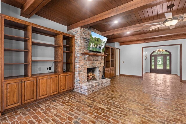 27076 Interstate 10, Winnie, TX 77665 - unfurnished living room with wood ceiling with exposed beams, baseboards, a brick fireplace, brick floors, and a chandelier