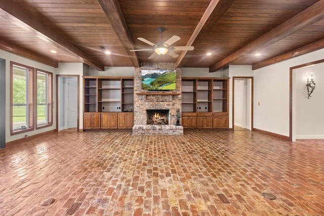 27076 Interstate 10, Winnie, TX 77665 - unfurnished living room with wood ceiling with exposed beams, baseboards, a brick fireplace, a ceiling fan, and brick floors