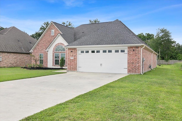 view of front of property with a front lawn, driveway, an attached garage, a shingled roof, and brick siding