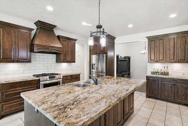 kitchen featuring custom exhaust hood, dark brown cabinets, stainless steel appliances, and a sink