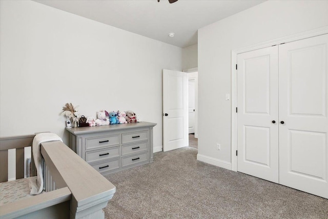 carpeted bedroom featuring a closet and baseboards