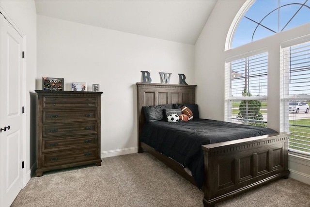 bedroom with baseboards, lofted ceiling, and light colored carpet