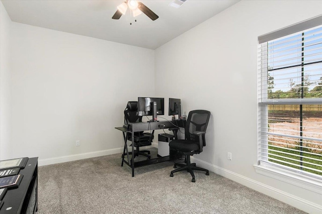 office space featuring baseboards, light colored carpet, and a ceiling fan