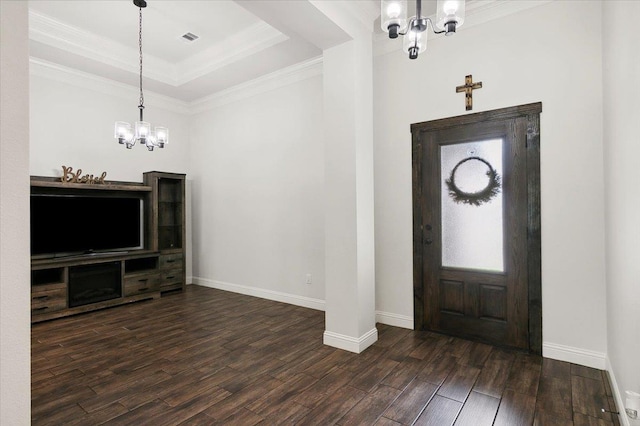 foyer featuring a tray ceiling, crown molding, dark wood-type flooring, and an inviting chandelier