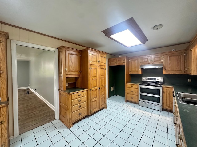 kitchen featuring sink, light tile patterned flooring, range with two ovens, and crown molding