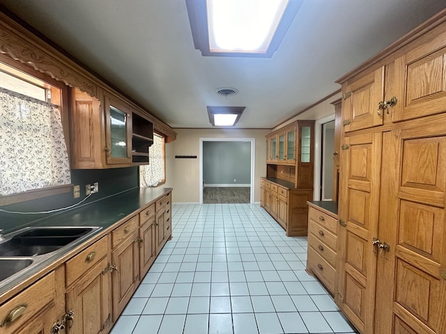 kitchen featuring light tile patterned floors, crown molding, a healthy amount of sunlight, and sink