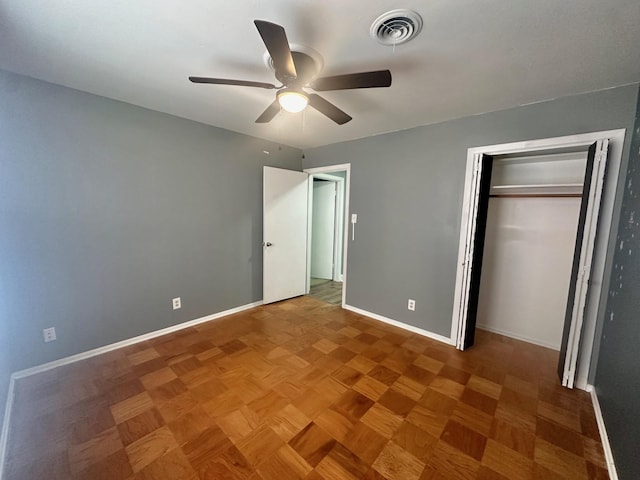 unfurnished bedroom with parquet flooring, a closet, and ceiling fan