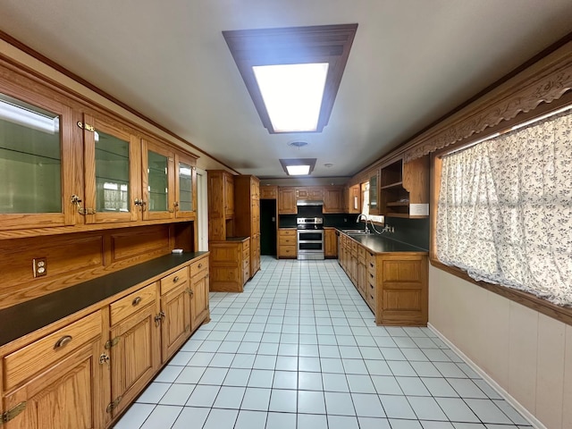 kitchen featuring crown molding, sink, stainless steel range with electric cooktop, and light tile patterned floors