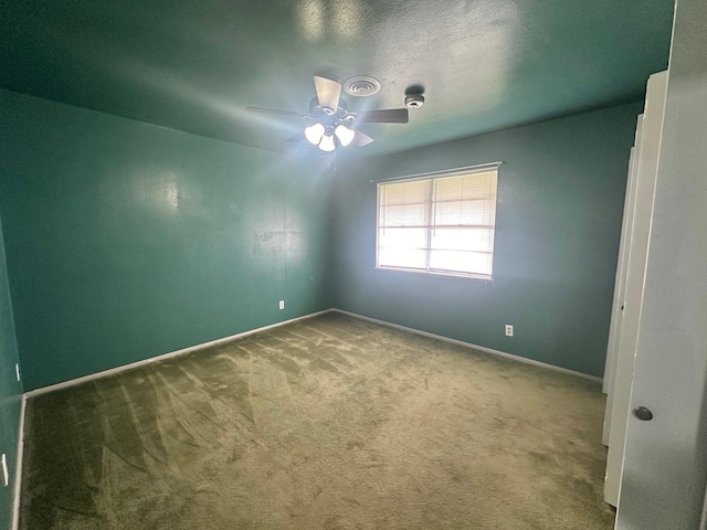 carpeted empty room featuring ceiling fan and a textured ceiling