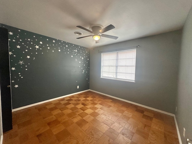 spare room with ceiling fan and parquet flooring