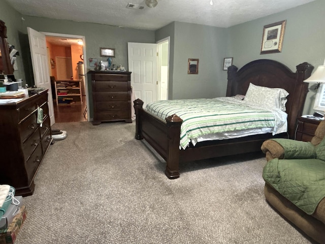 bedroom with light colored carpet and a textured ceiling