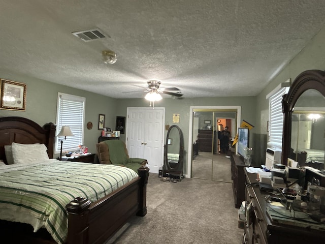 carpeted bedroom featuring ceiling fan and a textured ceiling