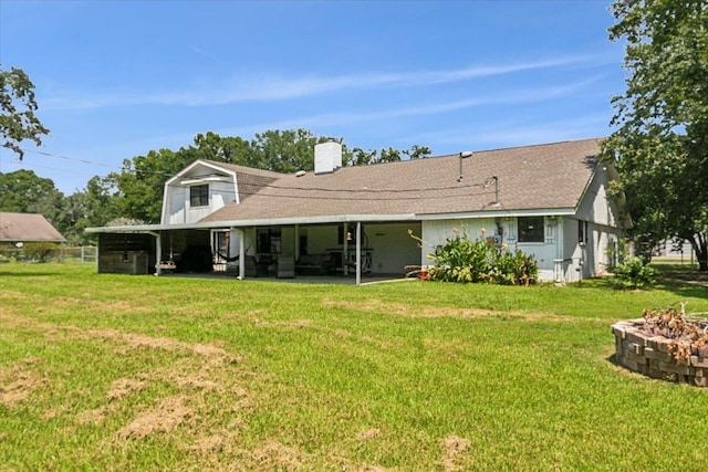 back of house featuring an outdoor fire pit, a patio, and a lawn