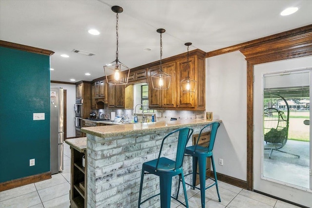 kitchen with pendant lighting, backsplash, light tile patterned floors, and kitchen peninsula