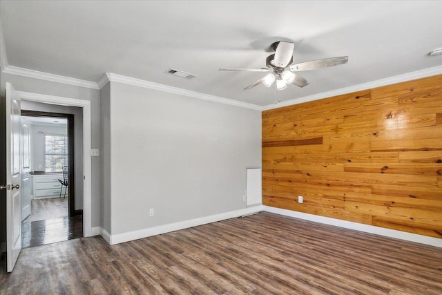 empty room featuring crown molding, dark hardwood / wood-style floors, and ceiling fan