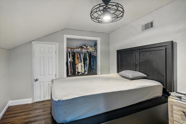 bedroom with lofted ceiling, dark hardwood / wood-style floors, and a closet