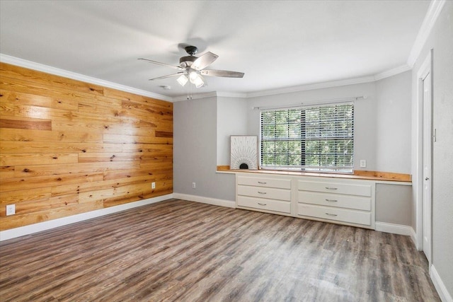 unfurnished bedroom featuring wood-type flooring, ornamental molding, wooden walls, and ceiling fan