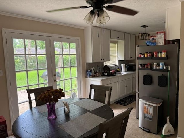 9325 Bamboo Ln, Beaumont, TX 77708 - dining room featuring a textured ceiling, ceiling fan, french doors, ornamental molding, and light tile patterned floors