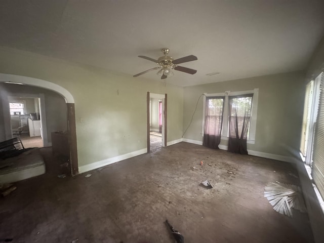 1598 Euclid St, Beaumont, TX 77705 - unfurnished living room with healthy amount of natural light, arched walkways, ceiling fan, and baseboards