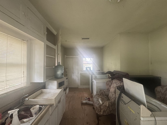 1598 Euclid St, Beaumont, TX 77705 - kitchen featuring white microwave, wood finished floors, a wood stove, white cabinets, and open shelves