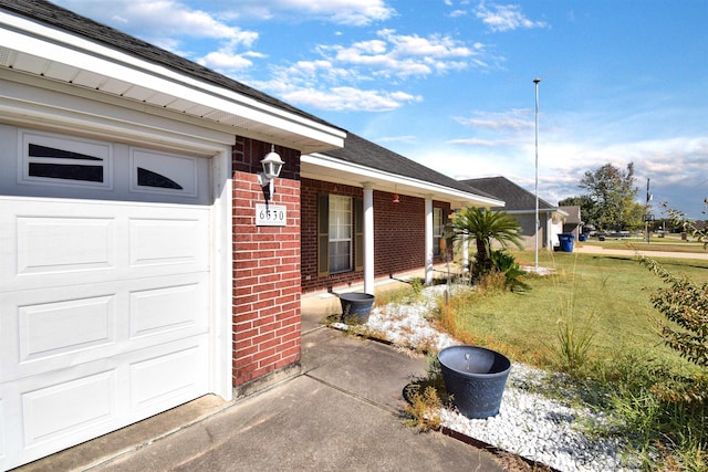 entrance to property featuring a yard and a garage