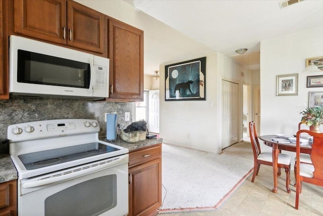 kitchen with tasteful backsplash and white appliances