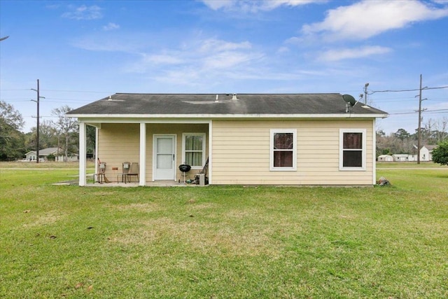 rear view of property with a yard and a patio area