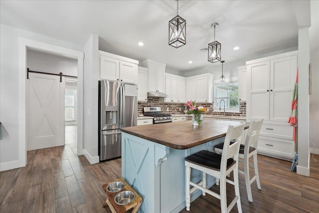 560 Lyndale St, Vidor, TX 77662 - kitchen with butcher block countertops, appliances with stainless steel finishes, under cabinet range hood, white cabinets, and recessed lighting
