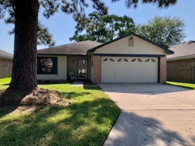 ranch-style house with a garage and a front lawn