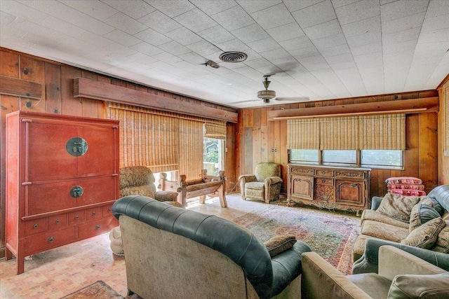 living room featuring ceiling fan, wood walls, and light colored carpet