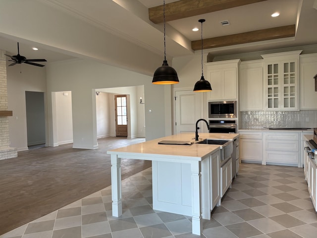 6560 Brayfield Ln, Beaumont, TX 77706 - kitchen with stainless steel appliances, open floor plan, white cabinets, ceiling fan, and light countertops