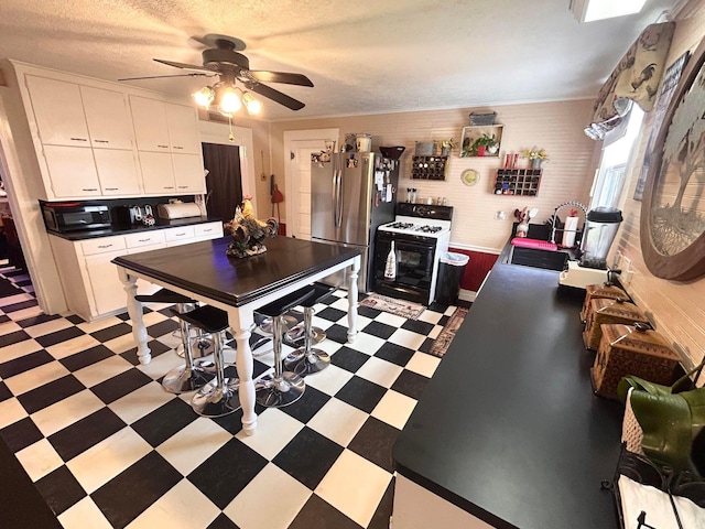 kitchen featuring stainless steel refrigerator, white cabinetry, sink, a textured ceiling, and white range with gas cooktop