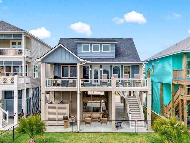 rear view of house with a fenced backyard, stairs, a lawn, and board and batten siding