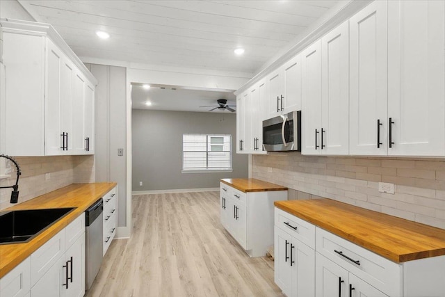 kitchen featuring ceiling fan, white cabinetry, sink, wood counters, and appliances with stainless steel finishes