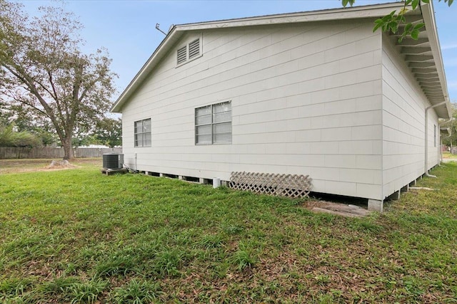 view of side of property with a yard and central air condition unit