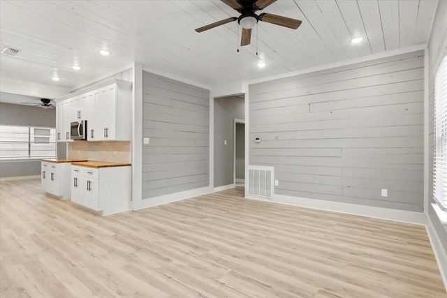 unfurnished living room featuring wooden ceiling, a healthy amount of sunlight, and light hardwood / wood-style floors