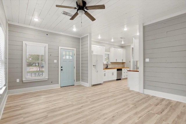 unfurnished living room featuring wood walls, sink, light hardwood / wood-style flooring, ceiling fan, and wood ceiling