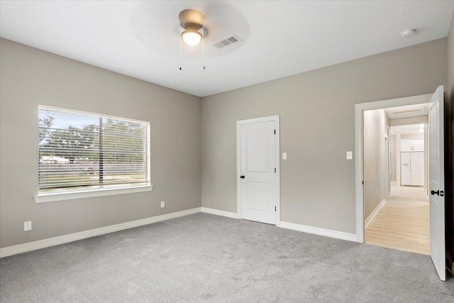 unfurnished room featuring light carpet and ceiling fan