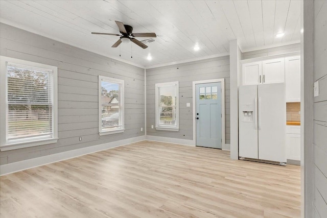 interior space featuring light hardwood / wood-style flooring, ceiling fan, wood walls, and wood ceiling