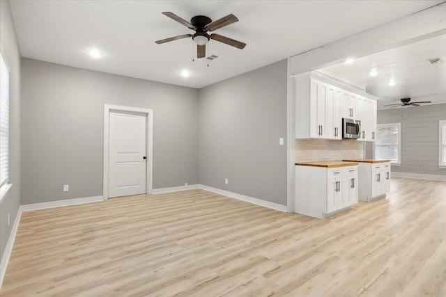 kitchen with white cabinetry, ceiling fan, wooden counters, light hardwood / wood-style floors, and decorative backsplash