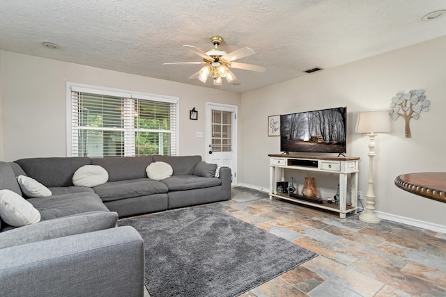 970 Evergreen Ln, Beaumont, TX 77706 - living room featuring a ceiling fan, stone tile flooring, baseboards, and a textured ceiling