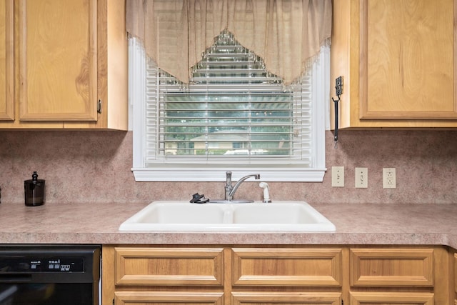 970 Evergreen Ln, Beaumont, TX 77706 - kitchen with black dishwasher, a sink, light countertops, and tasteful backsplash