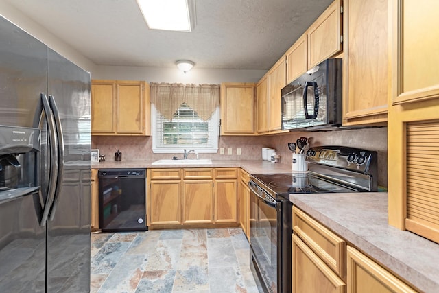 970 Evergreen Ln, Beaumont, TX 77706 - kitchen with black appliances, a sink, light countertops, light brown cabinetry, and light stone finish flooring