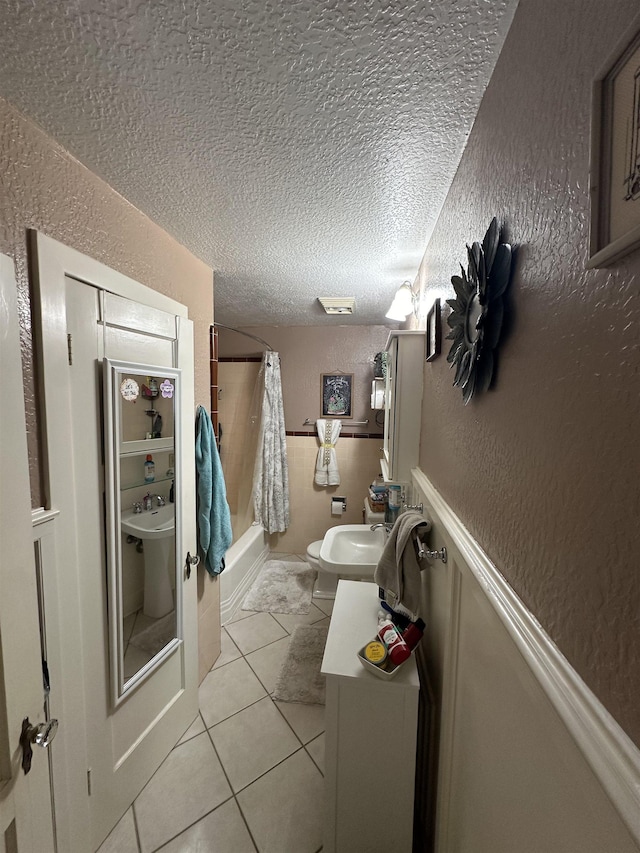 bathroom with tile patterned flooring, a textured ceiling, toilet, and shower / bathtub combination with curtain