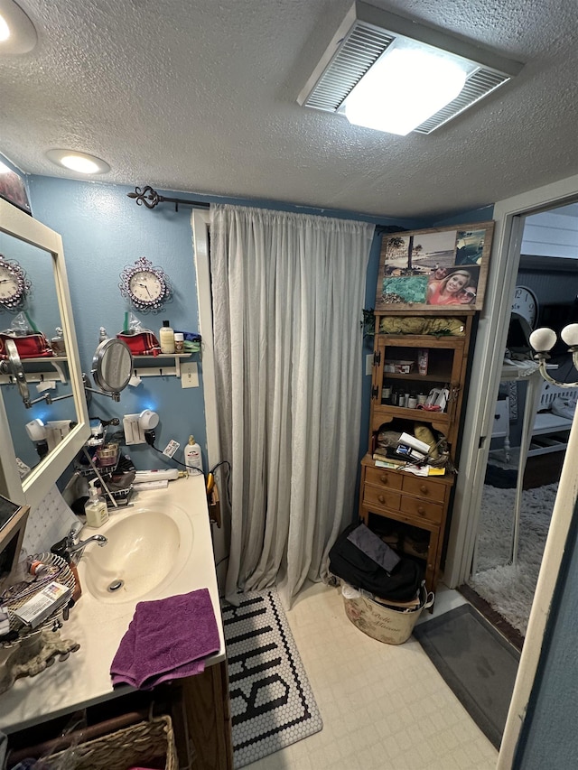 bathroom featuring vanity and a textured ceiling