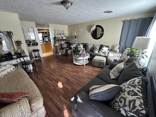 living room with hardwood / wood-style flooring and wooden walls